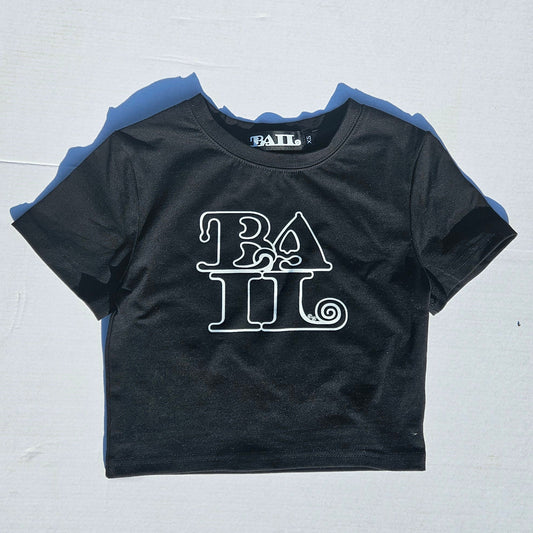 A black short-sleeve crop top t-shirt with a white graphic print reading 'BAIL' on the front, laid flat on a white background.